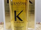 the bottle of kerastasee elixir ultimate hair oil next to a box of kerastasee elixir
