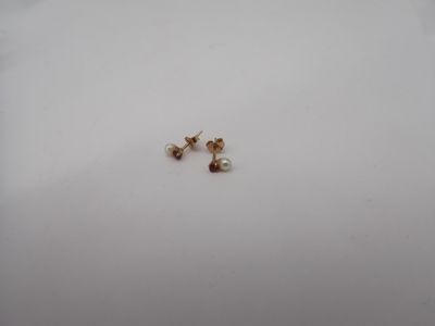 a close up of a pair of earrings sitting on top of a white surface