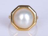 a close up of a ring with a white pearl in it