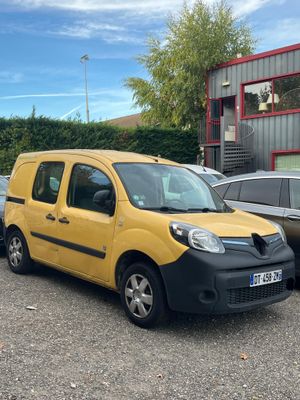yellow van parked in a parking lot next to other cars