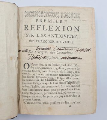 un vieux livre sur lequel figurent des inscriptions noires, posé sur une table