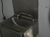 un évier en acier inoxydable dans le coin d'une salle de bains