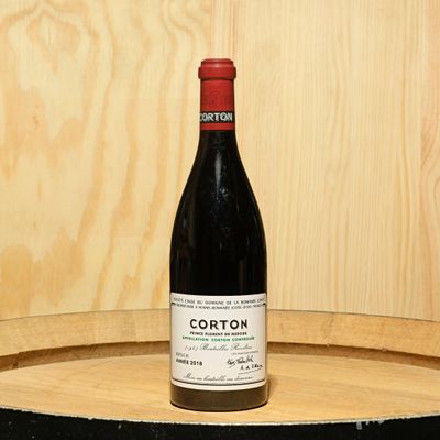 a bottle of wine sitting on top of a barrel