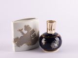 a small blue vase with a gold lid next to a white box