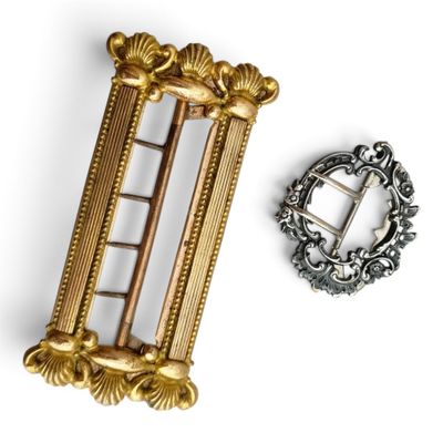 une broche en or et une broche en argent sur fond blanc