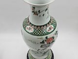 a white vase with a green and red design on it