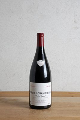 la bouteille de vin rouge est posée sur la table en bois