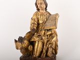 une image représentant la statue d'un homme assis sur un banc en train de lire un livre