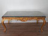 a table with a marble top on a wooden floor
