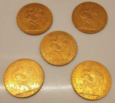 quatre pièces d'or sont posées sur une surface blanche