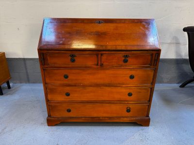 une commode en bois dans une pièce où se trouve une chaise