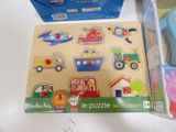 a wooden puzzle board with different types of toys