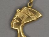 une image représentant un pendentif en or orné d'une tête de femme égyptienne