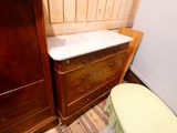 a dresser with a sink and a toilet in a room