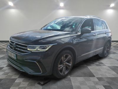 un SUV Volkswagen gris garé sur un sol à damier dans un garage