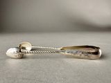 silver spoon and spoon rest on a table with a silver ball