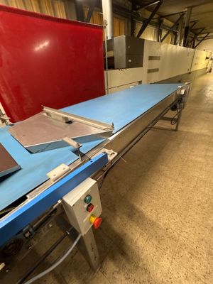 une photo d'un tapis roulant dans un entrepôt, sur lequel se trouve un ordinateur portable