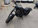 a black motorcycle parked in a parking lot next to a truck