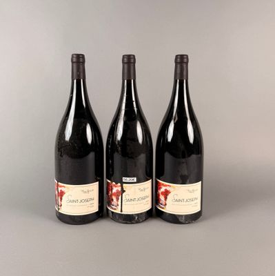 trois bouteilles de vin posées sur une table l'une à côté de l'autre