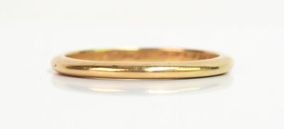 gros plan d'une bague en or sur une surface blanche