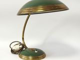 une lampe de bureau verte et dorée sur laquelle se trouve une horloge