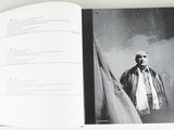 an open book with a picture of a man standing in front of a wall