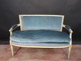 a blue couch with a gold frame and blue velvet upholstered