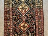 Un tapis persan ancien est posé au sol.