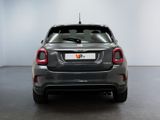 the rear end of a small grey car in a white room