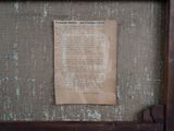 a piece of paper hanging on the wall next to a piece of paper