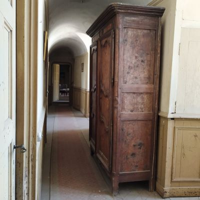 une grande armoire en bois au milieu d'un couloir
