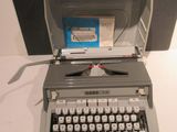 an old typewriter sitting on a table next to a box