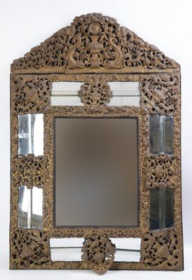 un vieux miroir avec un cadre en bois orné d'un motif floral