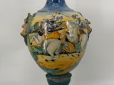 a blue vase with a picture of a man riding a horse on it