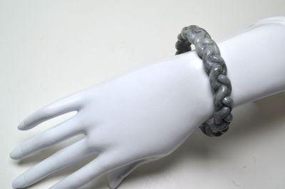 une main de mannequin blanche portant un bracelet