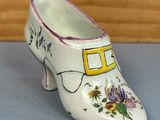 une petite chaussure blanche décorée de fleurs peintes