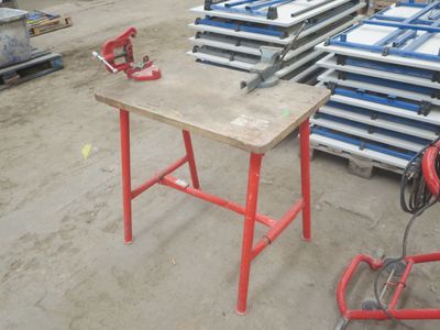 une table avec un piètement rouge et beaucoup de chaises bleues