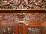 a wooden cabinet with carvings on the top of it