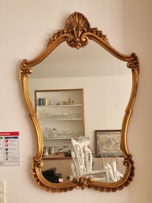 un miroir sur le mur au-dessus d'un lavabo dans une salle de bains