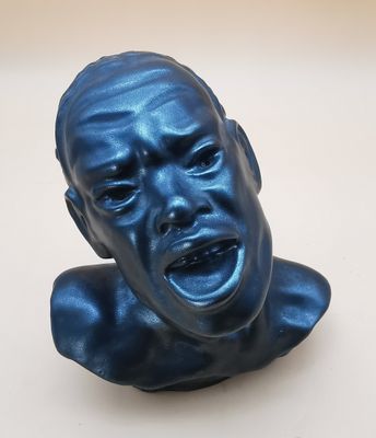 a blue sculpture of a man ' s face with his eyes closed