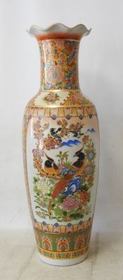 a vase with a bird design on it sitting on a table