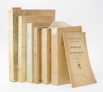 several books are stacked on top of each other on a white surface