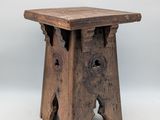 un vieux tabouret en bois troué, sur fond blanc