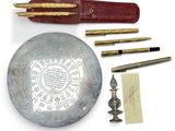 une assiette en argent sur laquelle est inscrit un texte, ainsi qu'un stylo et une paire de ciseaux