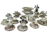a lot of cups and saucers that are sitting on a table