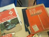 many books on a table with blue chairs in the background