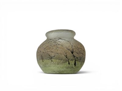 a vase that is sitting on the ground with trees in the background