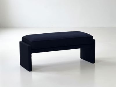 a black bench that is sitting on a white floor