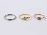three gold and silver rings on a white background
