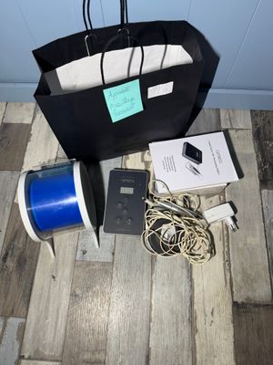 un sac noir muni d'une poignée bleue posé sur un plancher en bois
